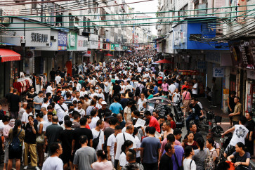 Job seekers and recruiters for garment factories gather on a street in Haizhu District, Guangzhou, Guangdong province, China, July 28, 2026.