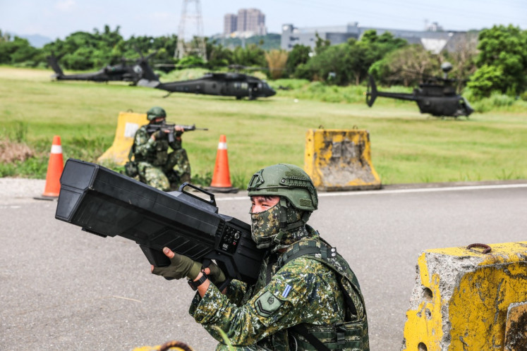 A Taiwanese soldier operates an anti-drone gun while providing security for helicopters during a fuel and ammunition resupply drill as part of the annual Han Kuang military exercise in Taoyuan on Aug. 11, 2026.