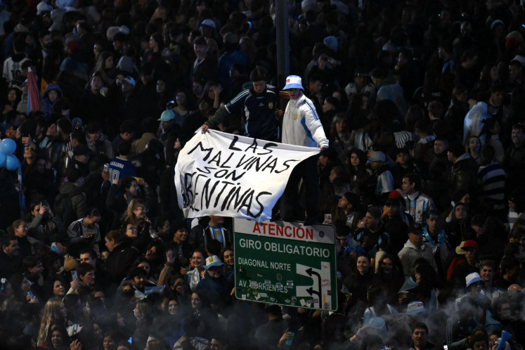 Argentina's fans hold a banner reading &ldquo;The Malvinas are Argentine&ldquo; on July 19 as they gather near the Obelisk after Argentina lost the FIFA World Cup final soccer match against Spain in Buenos Aires.