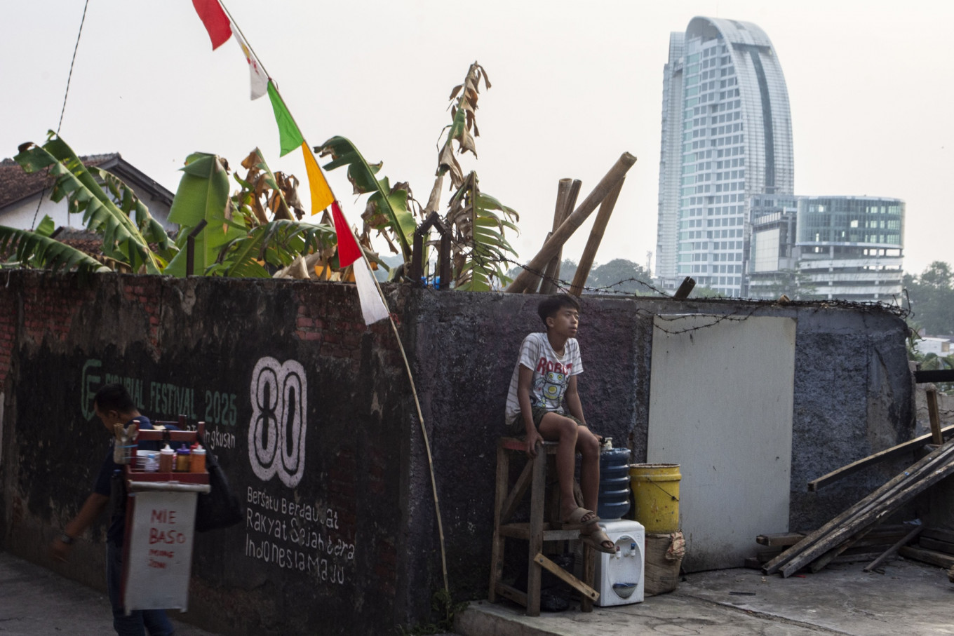 A boy sitsnon Aug. 5 at the Dago residential area in Bandung, West Java. The West Java office of Statistics Indonesia (BPS) recorded a decrease in the urban poor population from 2.83 million people in September 2025 to 2.7 million in March.