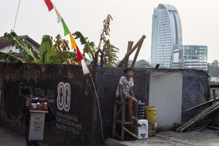 A boy sitsnon Aug. 5 at the Dago residential area in Bandung, West Java. The West Java office of Statistics Indonesia (BPS) recorded a decrease in the urban poor population from 2.83 million people in September 2025 to 2.7 million in March.