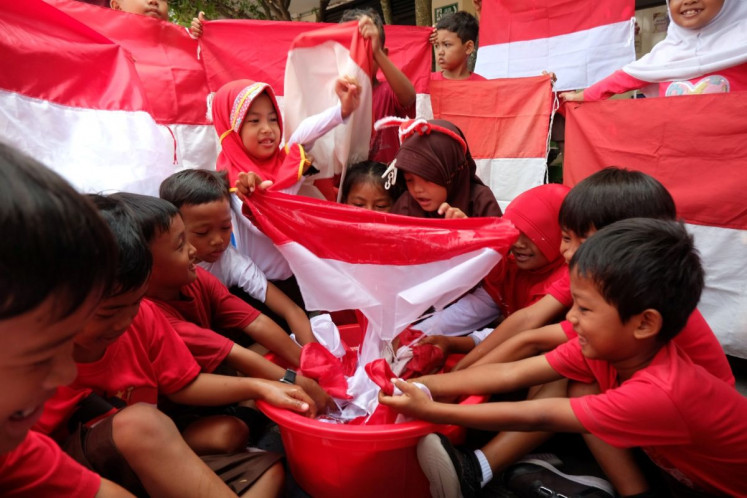 True colors: Students of SDN Mojosongo 3 state elementary school in Surakarta, Central Java wash Red and White national flags on Aug. 7, 2026 ahead of the 81st anniversary of Indonesian independence.