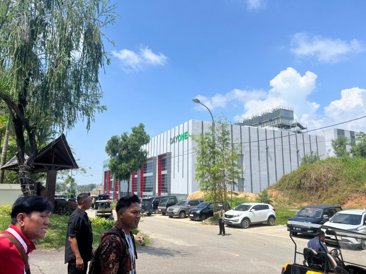 People walk near the DayOne data center on July 20 at Nongsa Digital Park (NDP) in Batam city, Riau Islands. Batam has attracted at least 16 new data centers in various stages, despite limited clean water and electricity infrastructure.