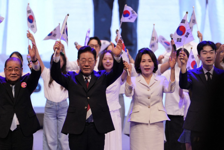 South Korean President Lee Jae Myung (center left) and his wife Kim Hea Kyung (centre right) wave the national flags during a ceremony to celebrate the 81st anniversary of the Korean Liberation Day in Seoul on Aug. 15, 2026.