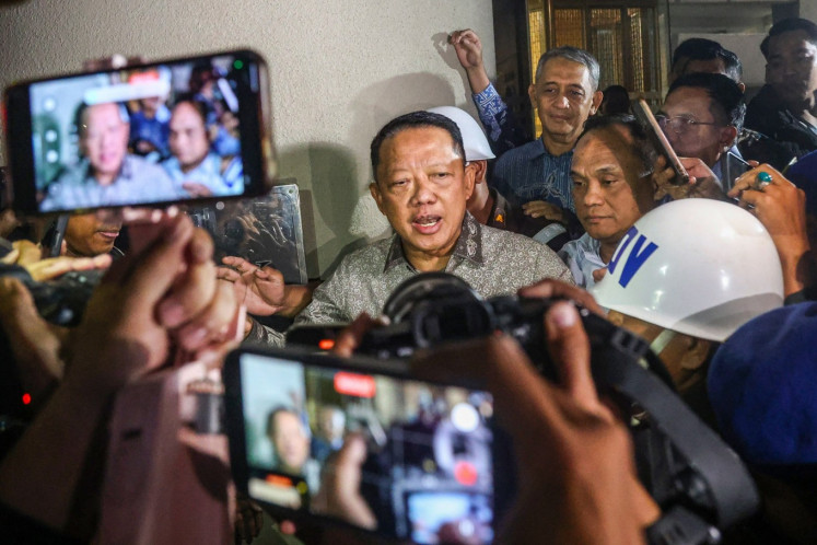 Former assistant attorney general for special crimes Febrie Adriansyah (center) is escorted to a prisoner van after undergoing a questioning at the Attorney General's Office (AGO) building in South Jakarta on July 24, 2026. The AGO named Febrie as a suspect in a money laundering case. 