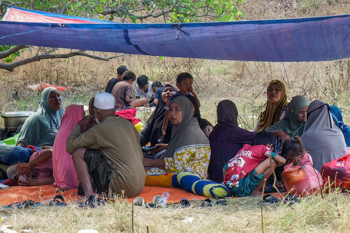 Villagers look on after spending the night in an open field in Nangahale village in Sikka, East Nusa Tenggara (NTT), on August 16, 2026, after a magnitude 7.7 earthquake off Indonesia's eastern Flores island. Rescuers combed through debris for survivors on August 15 after a powerful earthquake struck off Flores island, killing at least 47 people, according to disaster officials.