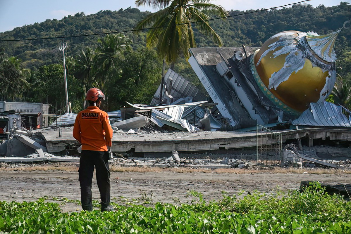 This handout photo taken and released on Monday by the National Search and Rescue Agency (BASARNAS) shows a rescuer conducting operations near a collapsed mosque following a 7.7-magnitude earthquake in Satar Kampas village, East Manggarai, East Nusa Tenggara (NTT). The 7.7-magnitude quake early on Saturday killed 54 people and injured more than 100. Rescue officials have said there were no reports of people missing.