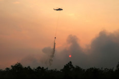 A helicopter drops water on burning forests and land in the Petuk Katimpun area, Palangka Raya, in Central Kalimantan, on Aug. 13, 2026. 