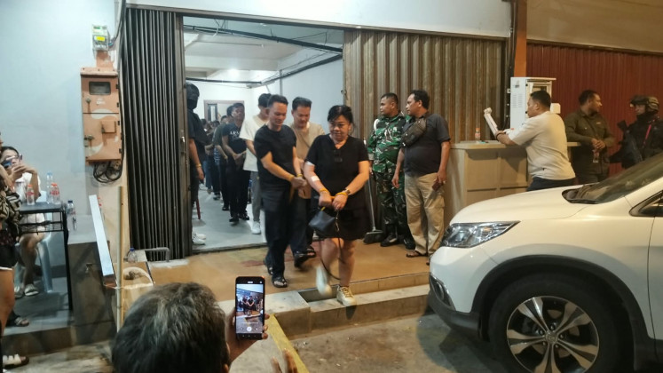 Detectives escort detainees during a raid at the Nine Stage Lounge and Bar in Nagoya Indah Shophouse Block B2 No. 9, in Batam, Riau Islands, on Aug. 15, 2026. Detectives from the National Police's Criminal Investigation Agency (Bareskrim) raided the gambling den in cooperation with the Riau Islands Police and Batam, Rempang and Galang (Barelang) Police, arresting 197 staff and gamblers as well as Rp 7.79 billion (US$435,715) in cash. 