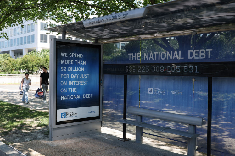 A Peterson Foundation bus stop sign displays the national debt on June 12, 2026, in Washington, DC.