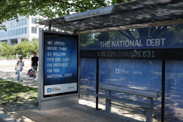 A Peterson Foundation bus stop sign displays the national debt on June 12, 2026, in Washington, DC.