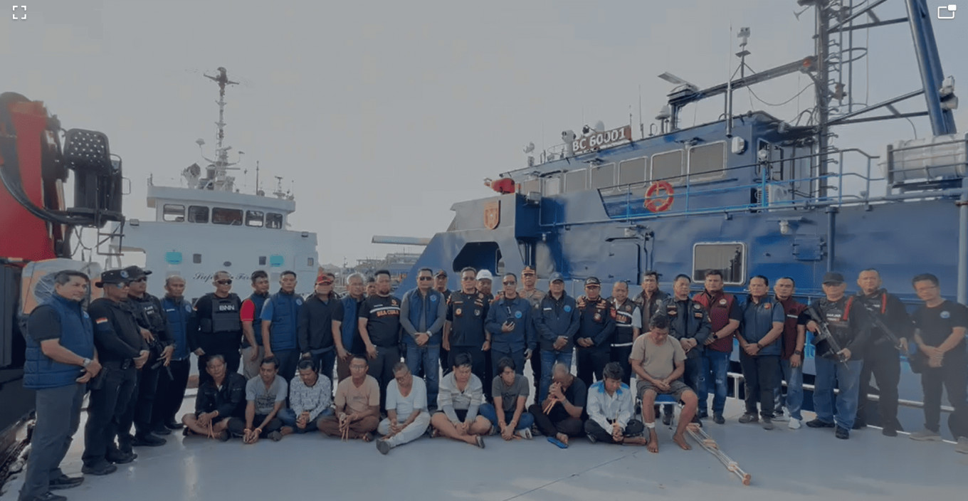 Officers from the National Narcotics Agency (BNN), the Customs and Excise Directorate General and the Riau Islands Police pose with 10 Myanmar nationals, the crew of the Tanzanian-flagged MV Ocean Porter (previously the MV Rain Maker) on Monday at the Customs Operational Base in Tanjung Balai Karimun in Karimun regency, Riau Islands. A joint operation involving the agencies intercepted the MV Ocean Porter, which was carrying 2.6 tonnes of liquid sabu (methamphetamine).