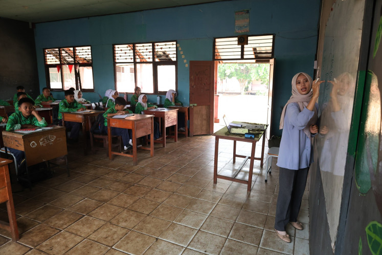 A teacher is seen in front of her class on Aug. 6 at SMPN 12 Sungai Raya state junior high school in Kubu Raya regency, West Kalimantan. Teaching and learning activities at the school resumed despite a fire burning a swath of peatland behind the school in the past two weeks.