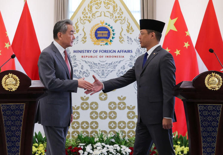 Foreign Minister Sugiono (right) shakes hands with Chinese Foreign Minister Wang Yi (left) as they attend a press conference on Aug. 21 after their meeting at the Foreign Ministry office in Jakarta.