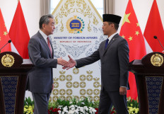 Foreign Minister Sugiono (right) shakes hands with Chinese Foreign Minister Wang Yi (left) as they attend a press conference on Aug. 21 after their meeting at the Foreign Ministry office in Jakarta.