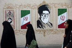 People walk by a mural depicting Iran's late Supreme Leader Ayatollah Ali Khamenei on a street in Tehran, Iran, on Aug. 13, 2026.