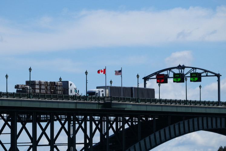 Trucks pass over the Peace Bridge between Canada and the United States in Fort Erie, Ontario, Canada on Aug. 18, 2026.