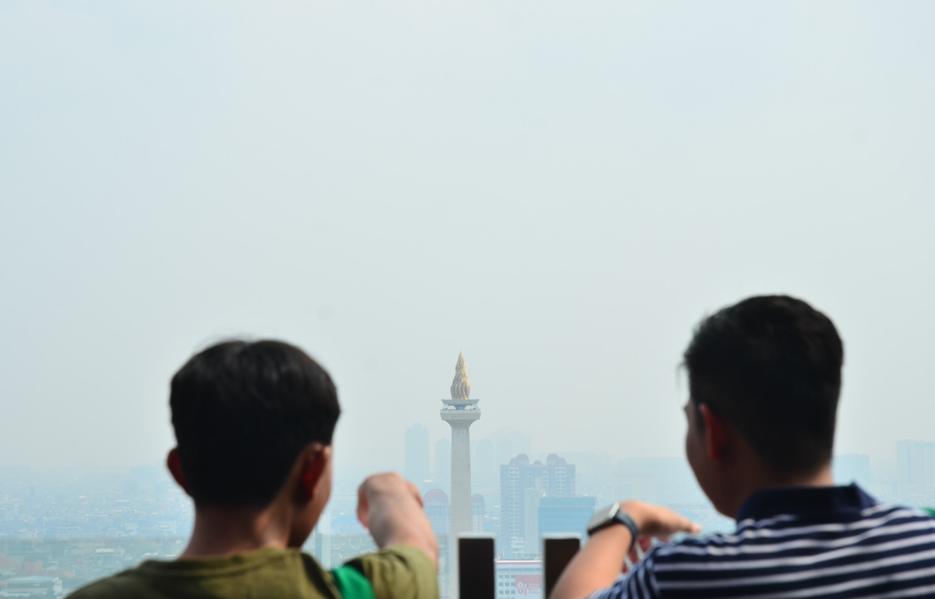 Visitors look at the National Monument (Monas) against a backdrop of air pollution, from the balcony of the National Library on Jl. Medan Merdeka Selatan on Sunday in Central Jakarta.