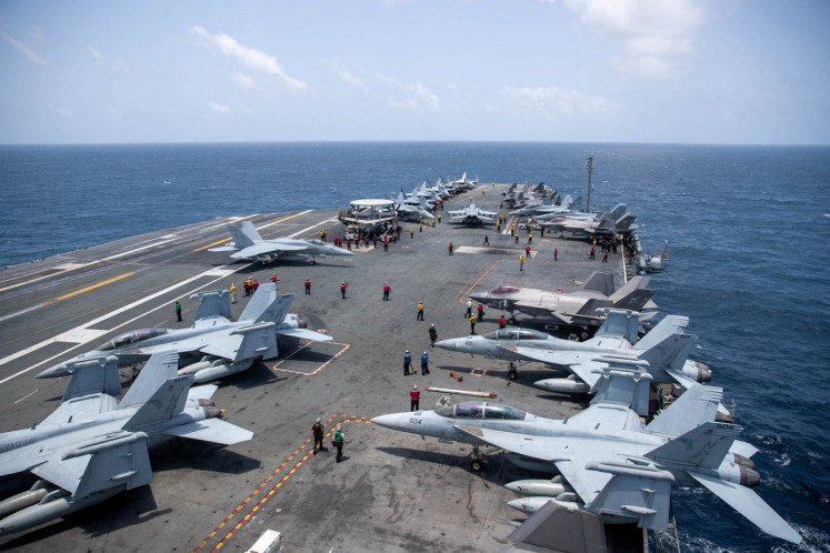 US Navy sailors work on the flight deck of the aircraft carrier USS George Washington as it transits the Arabian Sea to support US military operations in the war with Iran August 20, 2026.