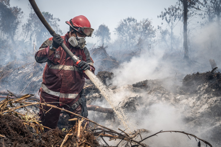 A fireman extinguishes a peatland fire on Aug. 24, 2026, in Kampar regency, Riau. The Riau provincial administration and other agencies reduced the area affected by forest and land fires from about 16,000 to 900 hectares between January and August 2026. 