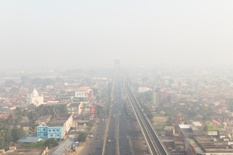 A drone view shows the Ampera Bridge shrouded in haze from wildfires in Palembang, South Sumatra, August 23, 2026.