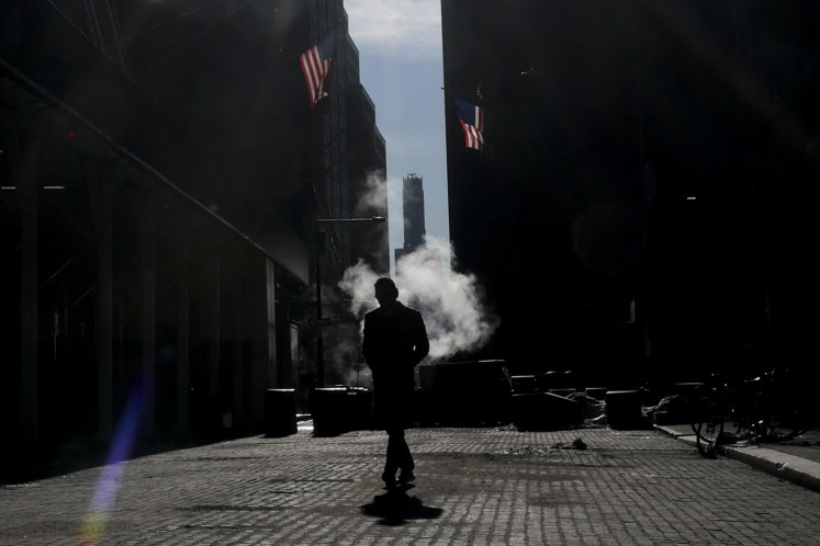 A person walks on Wall Street near the New York Stock Exchange (NYSE) on Feb. 13, 2026  in New York City, the United States.
