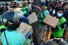 A group of &lsquo;ojol&rsquo; (online motorcycle transportation drivers) distributes boxes of supplies donated by the public at a drop-off point outside the Senalayan Legislative Complex in Central Jakarta on Aug. 25, 2026, ahead of a planned protest on Aug. 27.