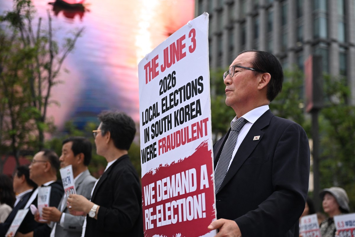 A man holds a banner claiming local elections held in June were fraudulent, during a protest demanding new elections on July 23 in Seoul.