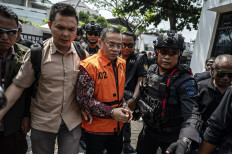 Suspended Pati regent (center) Sudewo is escorted by the police to a prisoner van on Aug. 10 after undergoing a corruption hearing at the Semarang Corruption Court in Semarang, Central Java. The Corruption Eradication Commission (KPK) suspects Sudewo of extorting candidates for village administration posts and accepting bribes pertaining to a 2022 railway project.