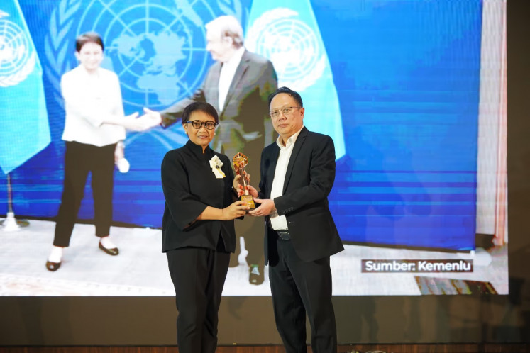 Editor-in-chief of SUAR.id, Sutta Dharmasaputra, presents the SUAR Prize to Retno LP Marsudi, former foreign minister who currently serves as special envoy on water to UN secretary-general, on Aug. 21 at the SUAR Forum in Tangerang, Banten.