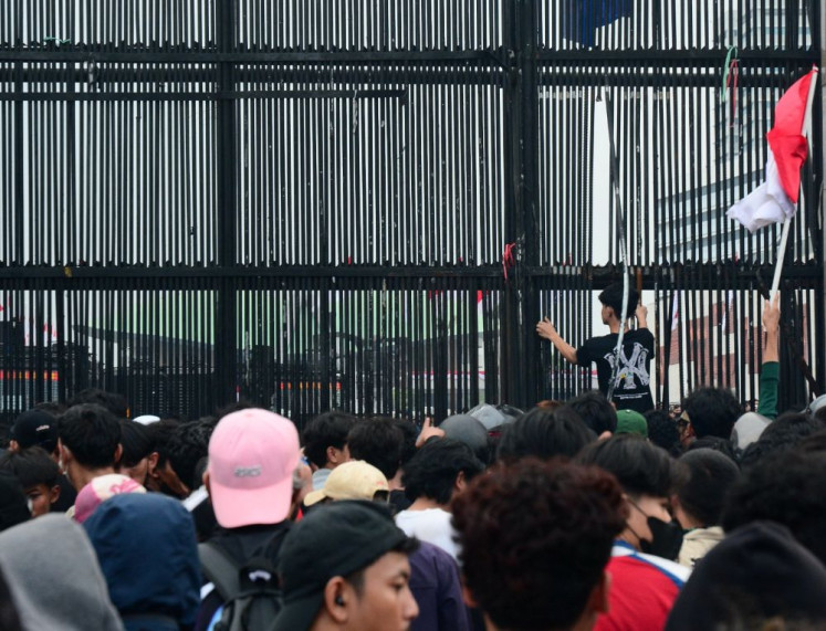 Locked out: Hundreds of people crowd the gate of the Senayan Legislative Complex in Central Jakarta on Aug. 27, 2026, during a mass demonstration that demanded passage of the long-delayed asset forfeiture bill and tougher punishment for corruptors.