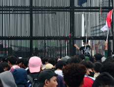 Locked out: Hundreds of people crowd the gate of the Senayan Legislative Complex in Central Jakarta on Aug. 27, 2026, during a mass demonstration that demanded passage of the long-delayed asset forfeiture bill and tougher punishment for corruptors.