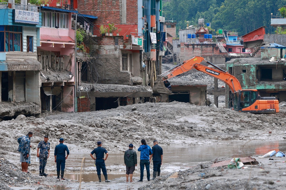 Workers use excavators to clear the mud at the Dhunge Bazaar in Nepal's Nuwakot district on Aug. 29, 2026 after flash floods and landslides hit the Nepal-Tibet border. Rescuers in Nepal and China were still battling Aug. 29 to locate thousands of people missing days after a deadly, tsunami-like wall of water and debris swept through the Himalayan region, engulfing villages.