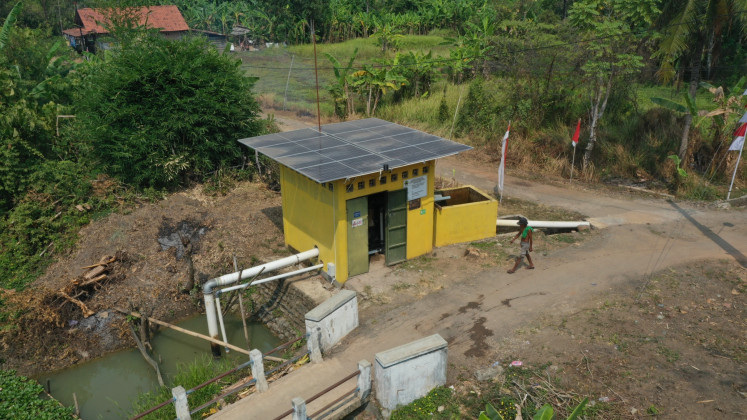 A farmer walks into a solar-powered water pump station on Aug. 22 in Tengengwetan village, Pekalongan, Central Java.  Solar-powered water pumps allow farmers to reduce diesel fuel consumption and thus their production cost.