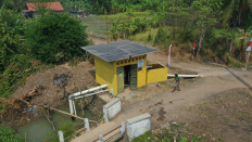 A farmer walks into a solar-powered water pump station on Aug. 22 in Tengengwetan village, Pekalongan, Central Java.  Solar-powered water pumps allow farmers to reduce diesel fuel consumption and thus their production cost.