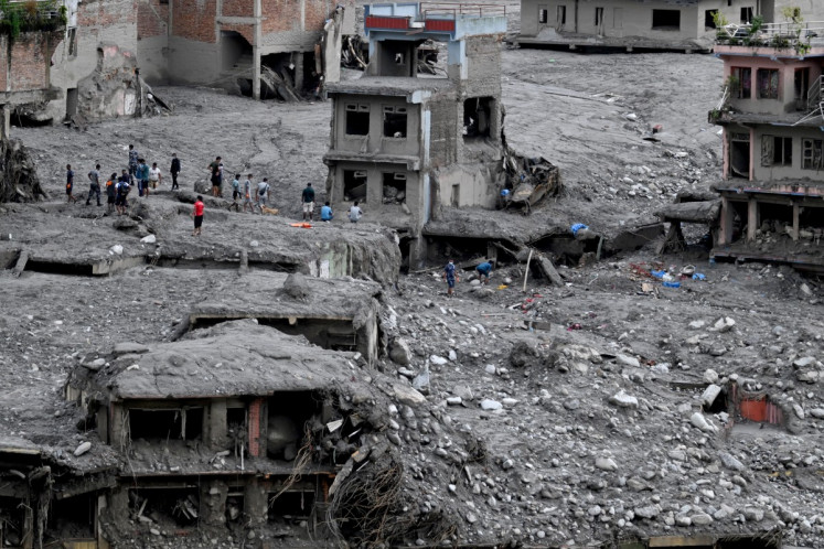 People scout for usable materials from debris after flash floods at Trishuli Center in Nepal's Nuwakot district on September 1, 2026. The huge wave of freezing water and debris, sparked by a glacial collapse on the China-Nepal border, killed at least 939 people and left nearly 4,500 missing, with Kathmandu warning reconstruction costs could run into the &ldquo;billions of dollars&ldquo;.