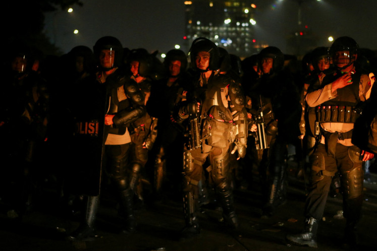 Riot police stand guard during a protest on Aug. 27 against government policies and demanding harsher penalties for corruption outside the Senayan Legislative Complex in Central Jakarta.