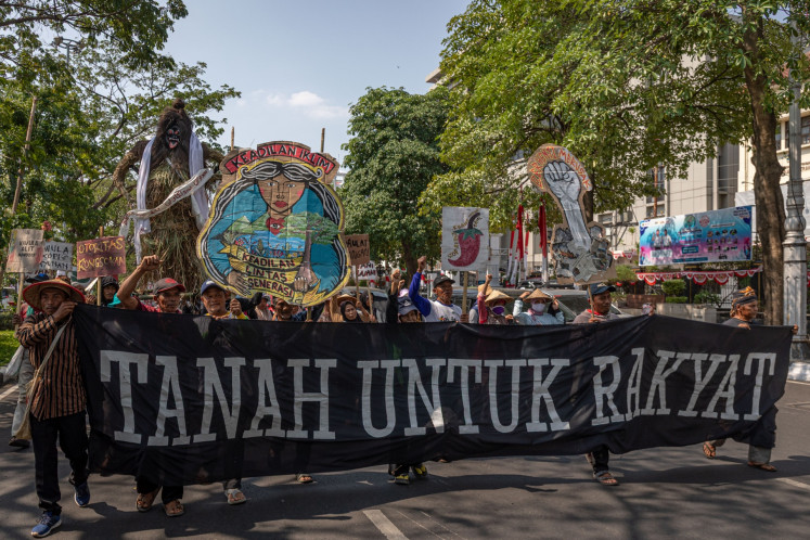 Farmers joined under the Kawulo Alit Mandiri Farmers Group hold a banner that reads &ldquo;Land for The People&ldquo; during a rally to protest against the criminalization of local farmers in Semarang, Central Java, on Aug. 3, 2026. The protesters demanded the Central Java Police stop the investigation into two local farmers, who were reported by a company for allegedly illegally taking control of a 16-hectare plot in Dayunan in Kendal regency.