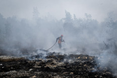 A firefighter from the Banjar Disaster Mitigation Agency (BPBD) douses a peatland fire on Sept. 2, 2026, in Banjar regency, South Kalimantan.