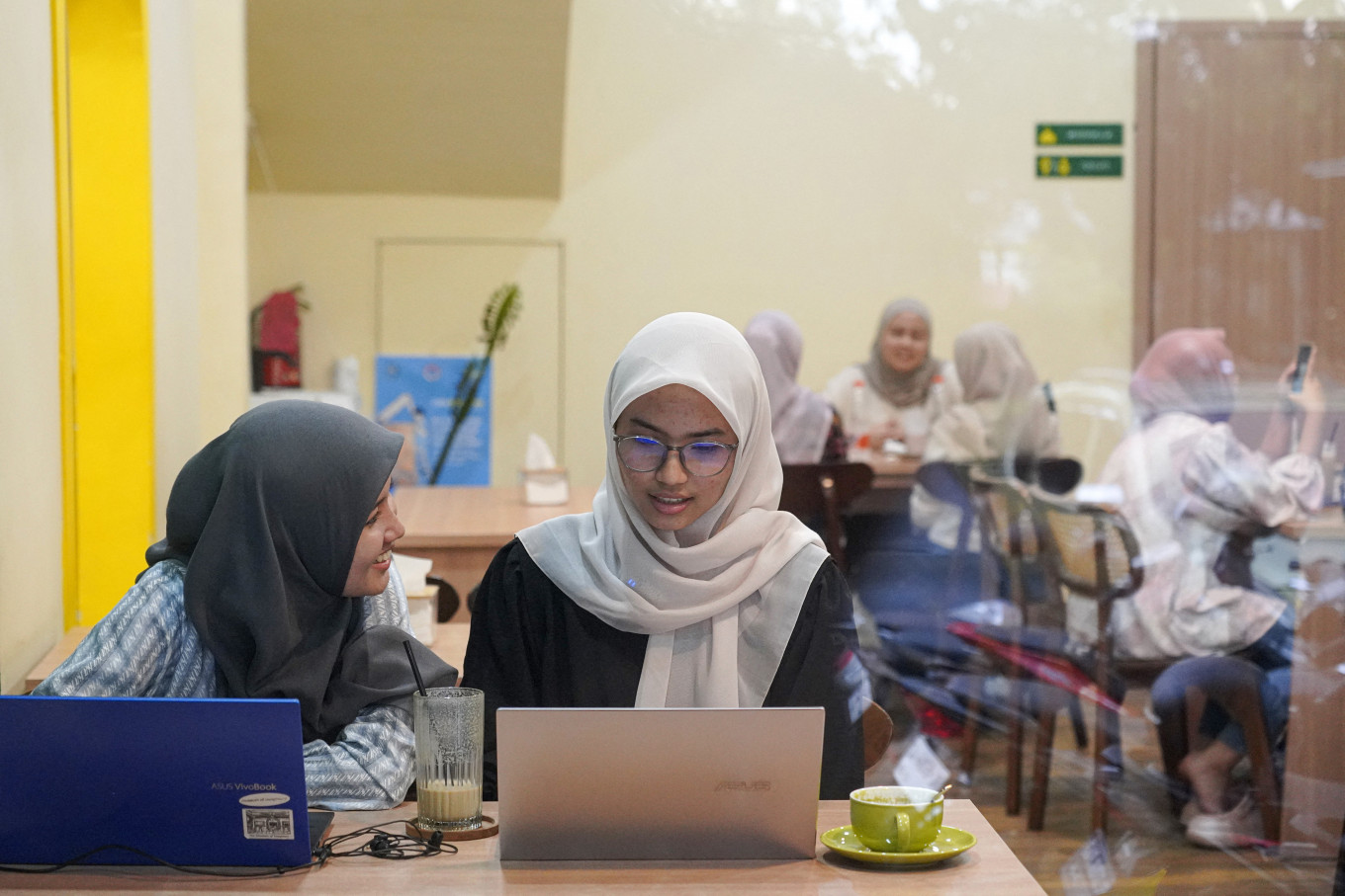 Finding balance: Women work on their laptops on Nov. 11, 2024, at Morning Mama cafe in Banda Aceh, Aceh, as demanding routines can blur the lines between work, sleep, meals and moments of rest.