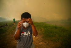 A boy reacts as smoke rises from&nbsp;wildfires in a residential area in Ogan Ilir, South Sumatra, on Sept. 2, 2026. 