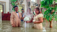 Bride Lhiane Galang (center) walks down the aisle at the St. John the Baptist Parish church during her wedding ceremony in a flooded church in Hagonoy town, Bulacan, the Philippines, on Sept. 1, 2026.