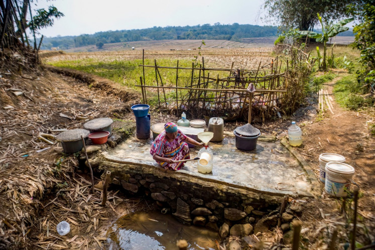A villager collects water from a remaining natural spring as the area is hit by a prolonged dry season at Wening Galih village in Bogor, West Java on August 28, 2026. 