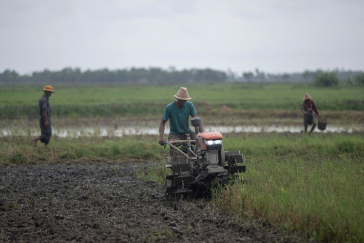A farmer plows a field with a tractor in Kawhmu township on the outskirts of Yangon on May 25, 2026. 