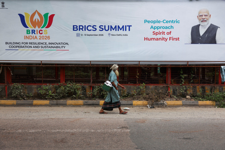 A man walks past a board featuring Indian Prime Minister Narendra Modi on Sept. 3, 2026, ahead of the upcoming BRICS Summit in New Delhi.