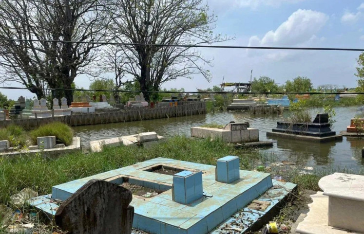 Graves beneath water: A row of gravestones is partially submerged in Eretan Wetan, Indramayu, West Java, in this undated photo.