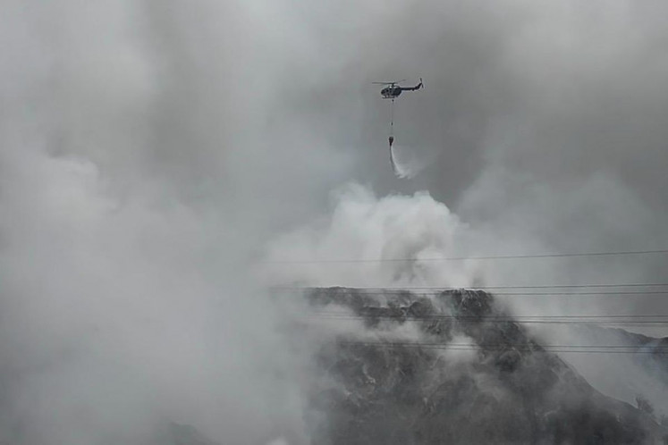 An NBO-105 light, multirole, twin-engine helicopter from the Yogyakarta Police drops 9,000 liters of water to extinguish a fire on Friday at the Putri Cempo landfill in Surakarta, Central Java. The fire has been burning some 6 hectares of Blocks B, C and D of the landfill since Wednesday.