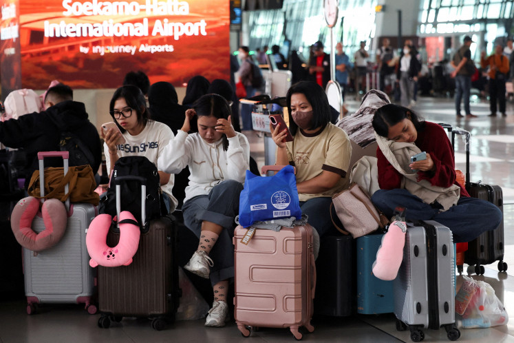 Stranded passengers wait in a terminal at Soekarno-Hatta International Airport in Tangerang on Sept. 7, 2026, after the main airport serving Jakarta halted operations following the eruption of Mount Anak Krakatau in the Sunda Strait.
