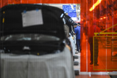 Workers assemble electric cars on Sept. 3 at a BYD factory in Subang, West Java. Indonesia&rsquo;s The Industry Ministry is seeking to increase the minimum domestic component level for electric vehicles to 80 percent by 2030 to support the development of the auto parts industry.