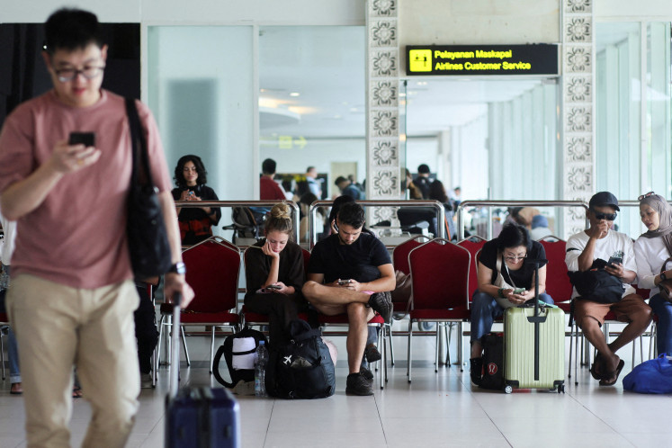 Stranded passengers wait at the domestic terminal of I Gusti Ngurah Rai International Airport in Kuta, Bali, on Sept. 7, 2026, as some flights to Jakarta were cancelled due to the eruption of Mount Anak Krakatau. 